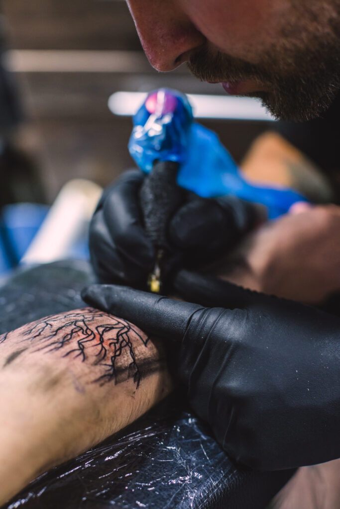 master-doing-tattoo-arm-with-needle