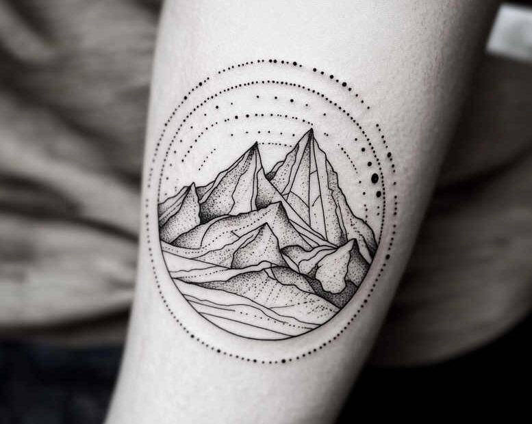 Mountain range within a circular dotted frame in black ink; tattoo design idea; black and grey; not ideal for cover-up.