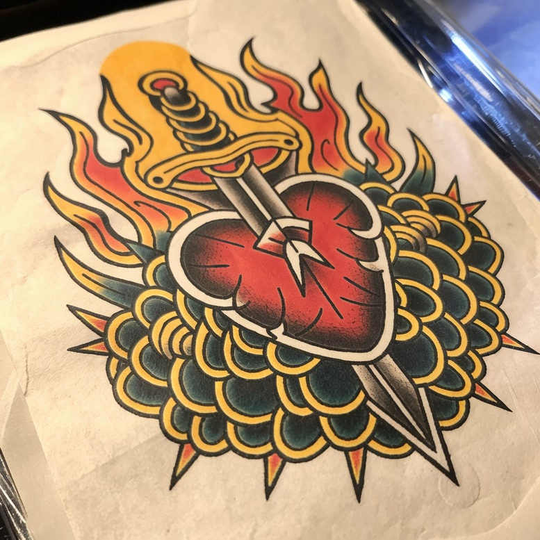 Colorful traditional tattoo design of a heart pierced by a dagger with flames, set against a green-yellow scalloped background; full color, project, not ideal for cover-up.