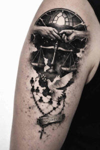 Black and grey tattoo of a globe held by hands with a rosary and cross pendant, a project idea, and perfect for cover-up.